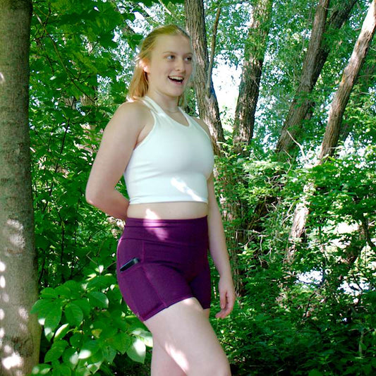 a woman in a bikini standing in a forest 