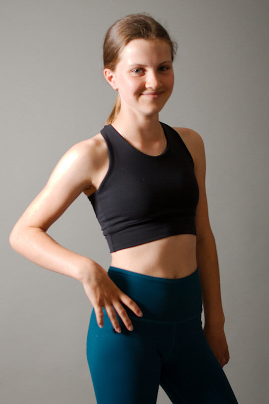 a woman in a short skirt standing next to a wall 