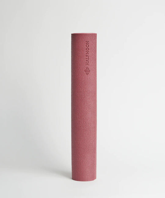 a pink toothbrush is sitting on a white surface 