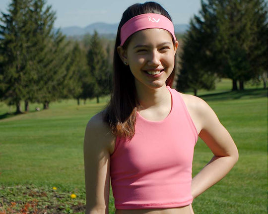 a woman in a pink dress holding a frisbee 