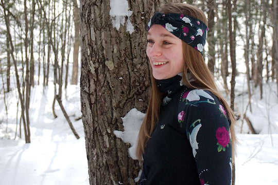 a woman is sitting on a tree in the snow 